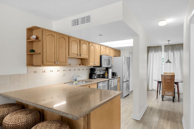 87200 Overseas Hwy Unit O9, Islamorada, FL 33036 - kitchen with open shelves, appliances with stainless steel finishes, a kitchen bar, a peninsula, and backsplash