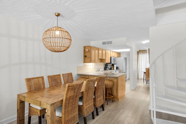 87200 Overseas Hwy Unit O9, Islamorada, FL 33036 - dining space with a chandelier and light wood-type flooring