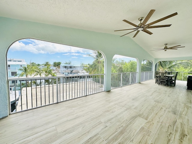 sunroom with ceiling fan and lofted ceiling