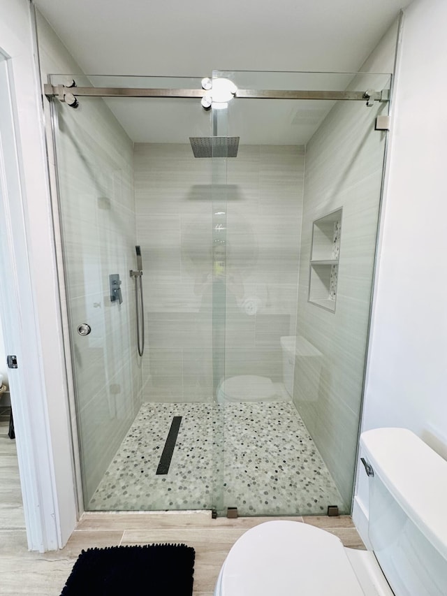 bathroom with toilet and a shower with shower door