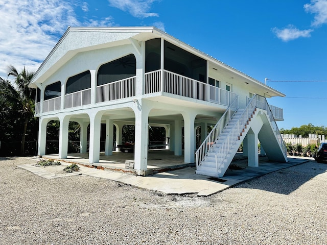 rear view of property with ceiling fan and a patio area