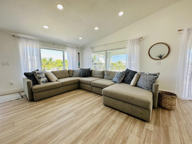 living room featuring high vaulted ceiling and light hardwood / wood-style floors