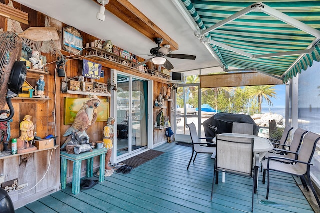 wooden terrace featuring ceiling fan and outdoor dining space