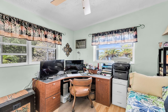 office area featuring ceiling fan, a wall mounted AC, and light wood-type flooring