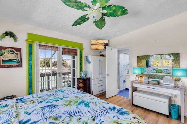 bedroom featuring a ceiling fan, french doors, access to exterior, and wood finished floors