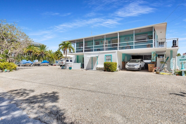 rear view of property featuring a carport and driveway