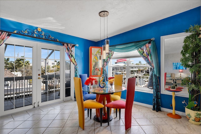 tiled dining space with french doors and baseboards