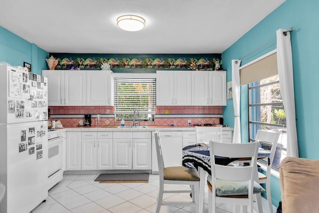 kitchen with tile countertops, a sink, a wealth of natural light, and white appliances