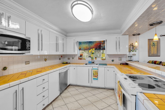 kitchen with white cabinets, appliances with stainless steel finishes, and tasteful backsplash