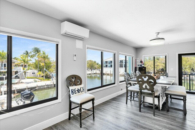 26 Corrine Pl, Key Largo, FL 33037 - dining room featuring baseboards, wood finished floors, a water view, and a wall mounted AC