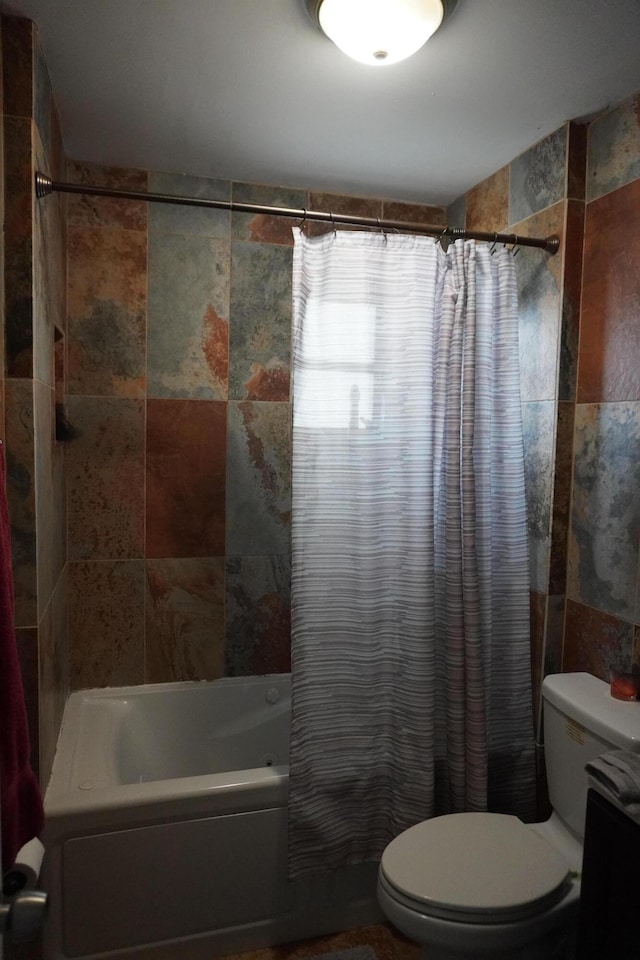 bathroom featuring tile walls, shower / bath combo with shower curtain, and toilet