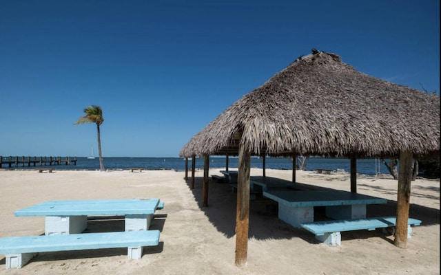 view of home's community featuring a water view, a view of the beach, and a gazebo