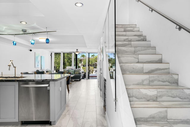 interior space with ceiling fan, floor to ceiling windows, a tray ceiling, and sink