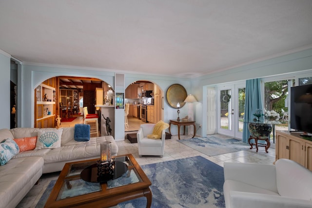 living area with arched walkways and crown molding