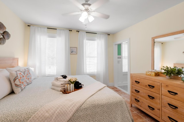 bedroom with ceiling fan, multiple windows, and light tile patterned floors