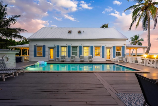 pool at dusk featuring a deck