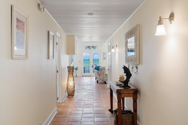 corridor featuring ornamental molding, light tile patterned flooring, and french doors