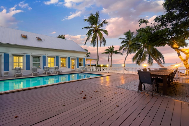 pool at dusk featuring a wooden deck