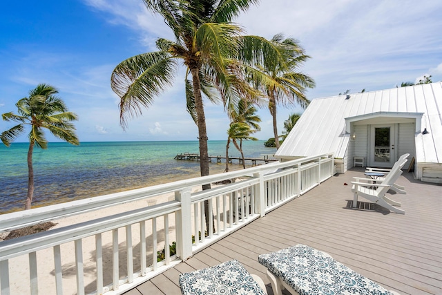 wooden terrace with a water view and a beach view