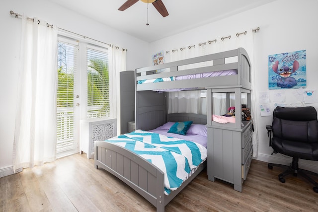 bedroom with access to outside, hardwood / wood-style floors, and ceiling fan