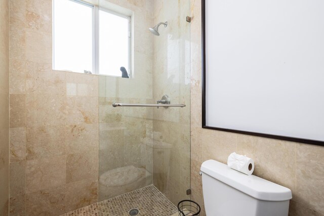 bathroom with toilet and a tile shower