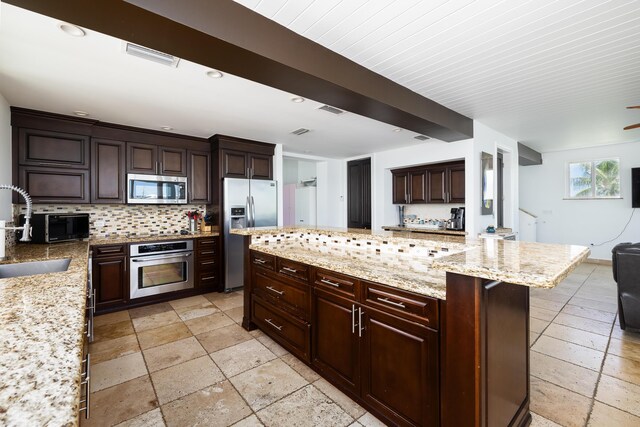 kitchen with sink, backsplash, stainless steel appliances, and light stone countertops