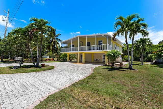 rear view of property featuring a lawn and a carport