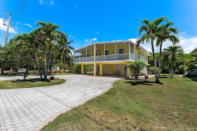 rear view of property featuring a lawn and a carport