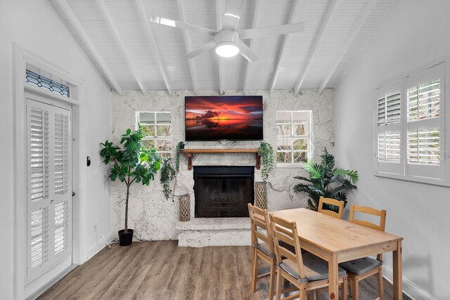 71 N Bay Harbor Dr, Key Largo, FL 33037 - dining area with a fireplace, a ceiling fan, beam ceiling, and wood finished floors