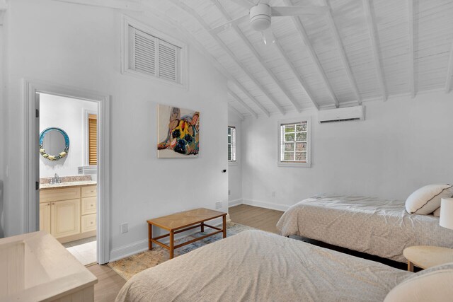 71 N Bay Harbor Dr, Key Largo, FL 33037 - bedroom with a wall mounted air conditioner, light wood-style floors, and ensuite bath