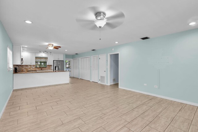 unfurnished living room featuring ceiling fan