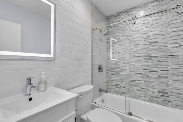 full bathroom featuring bath / shower combo with glass door, vanity, and toilet