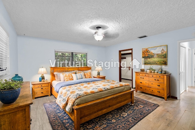 bedroom with light hardwood / wood-style flooring and a textured ceiling