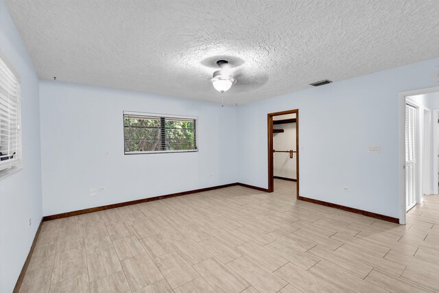 spare room featuring light hardwood / wood-style floors and a textured ceiling