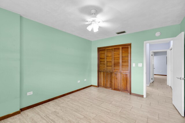 unfurnished bedroom with light hardwood / wood-style flooring, ceiling fan, and a closet