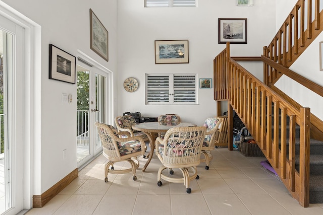 tiled dining area featuring french doors and a high ceiling