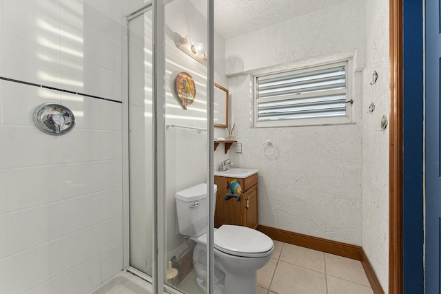 bathroom featuring tile patterned flooring, walk in shower, vanity, and toilet