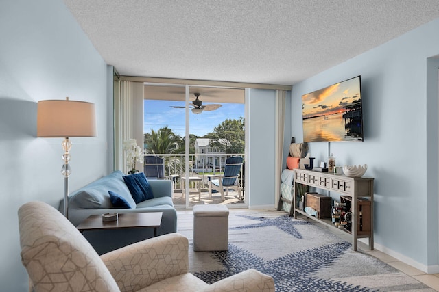 living area with a textured ceiling, baseboards, a ceiling fan, and floor to ceiling windows