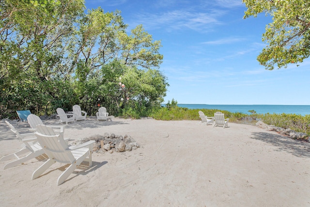 view of yard featuring a water view and a beach view