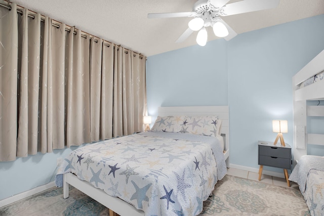 bedroom with ceiling fan, baseboards, and a textured ceiling