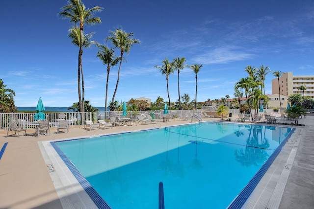 pool with a patio area and fence