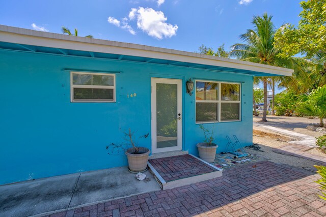 140 Gardenia St, Tavernier, FL 33070 - doorway to property featuring a patio area and stucco siding