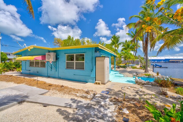 140 Gardenia St, Tavernier, FL 33070 - view of front of property featuring a swimming pool, a patio, and a cooling unit