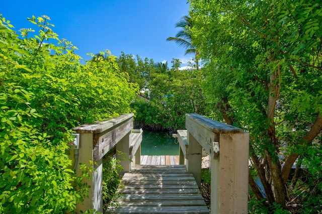 view of property's community with a water view and a dock