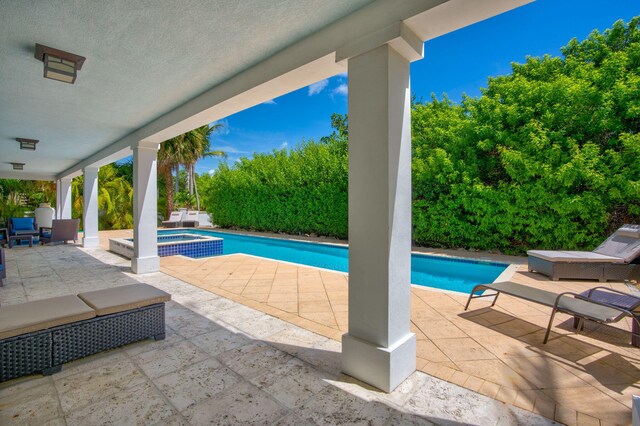 view of pool with a patio and an in ground hot tub