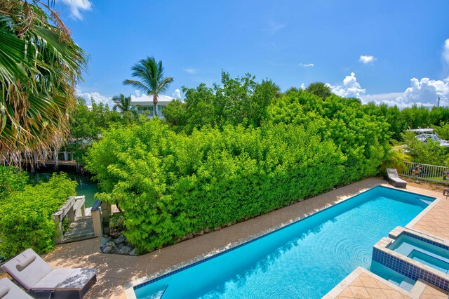 view of swimming pool with a patio area and an in ground hot tub