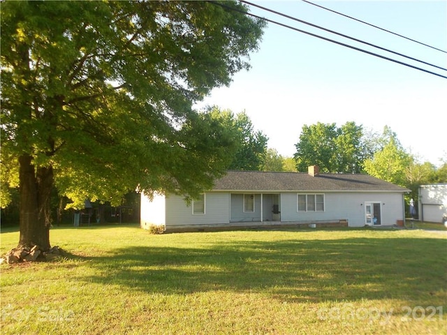 back of house with a lawn