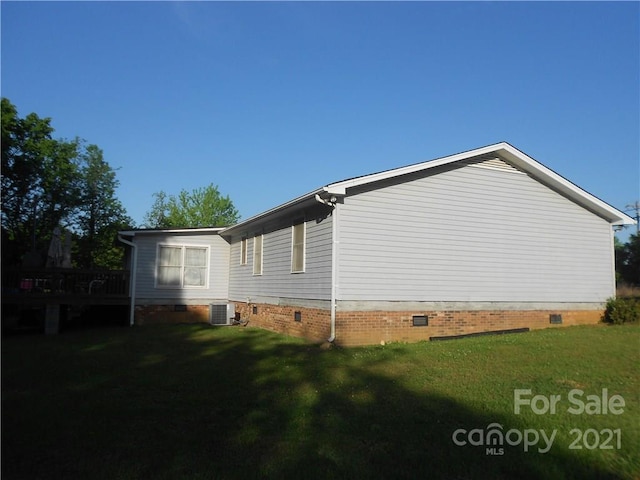 view of side of property featuring a lawn and central air condition unit