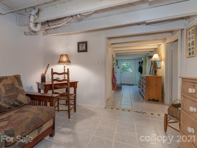 sitting room with light tile floors and beamed ceiling