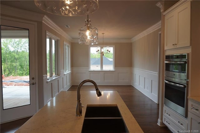 kitchen featuring crown molding, double oven, dark wood-type flooring, and light stone counters